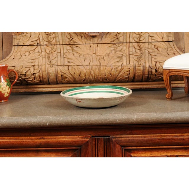 An Italian pottery bowl from the early 20th century, with rooster motif and green border. Created in Italy during the...