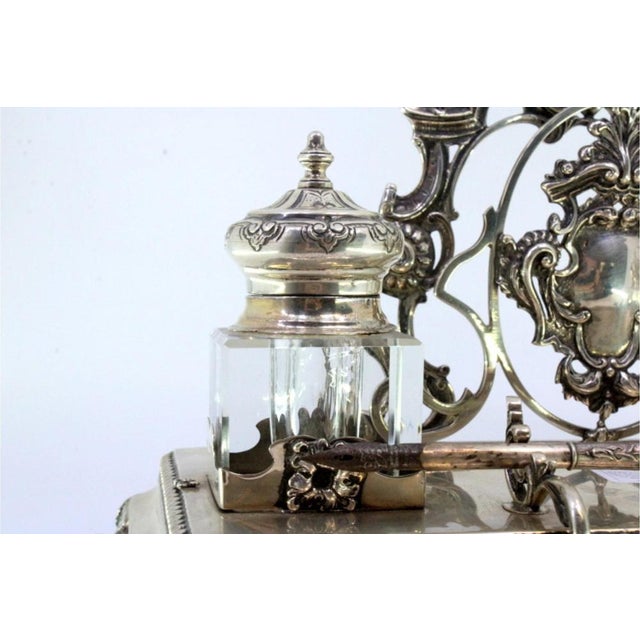 Cut silver inkwell with two glass containers, letter holder, pen holder, with monogram cards, supported on four raised...