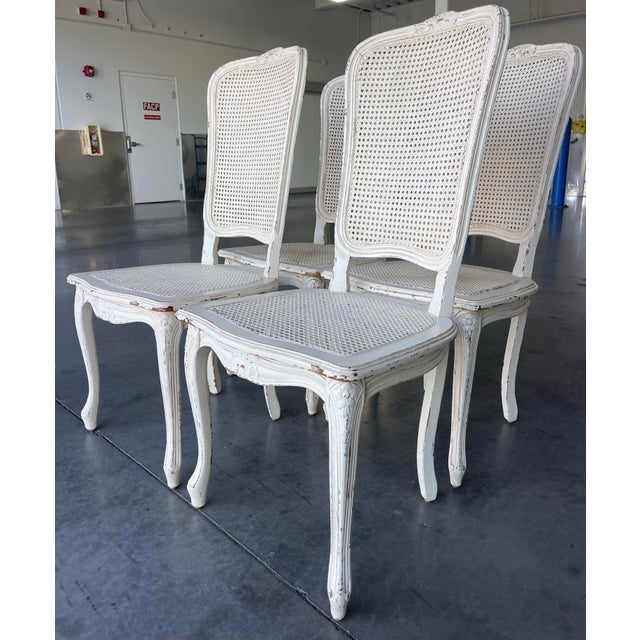 Elegant set of four Italian Louis XV style dining chairs featuring hand-carved frames with a soft, intentionally...