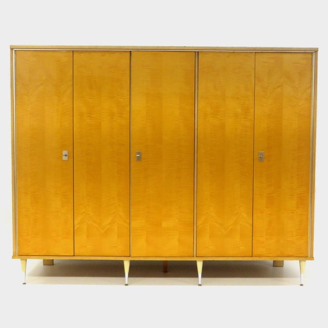 Large vintage 5-door wardrobe in flamed maple. This mid century modern wardrobe is equipped with stylish legs, features...