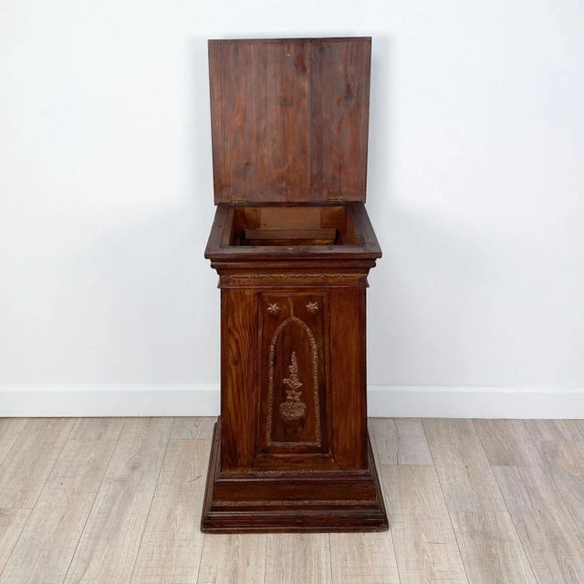 A Victorian pine pedestal, painted to look like hardwood, with gilt highlights.