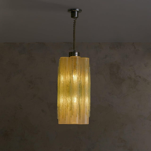 A 1970s Italian chandelier. Seven frosted Murano glass tubes, each hand-blown with a distinctive icicle-like texture, are...