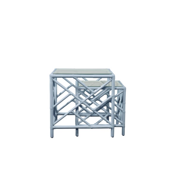 In a classic chinoiserie style, this set of two rattan nesting tables feature a rattan frame, rawhide bindings, hand...