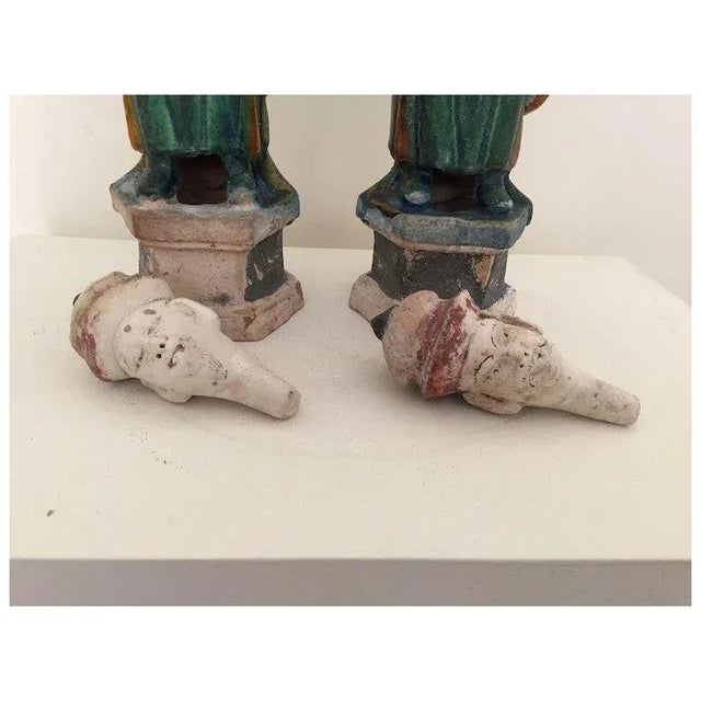 Large pair antique Chinese Ming style glazed pottery figures of grooms. Each wearing a green tunic with turquoise and...