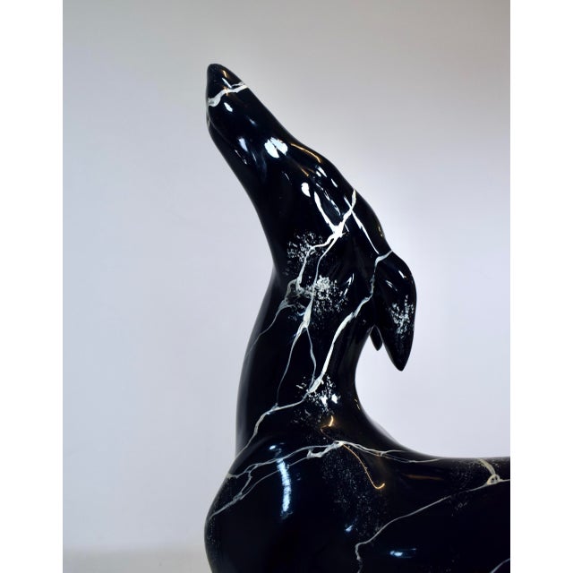A Highly stylized, postmodern Art Deco-inspired sculpture that captures the sleek, dramatic lines of a life-size greyhound...