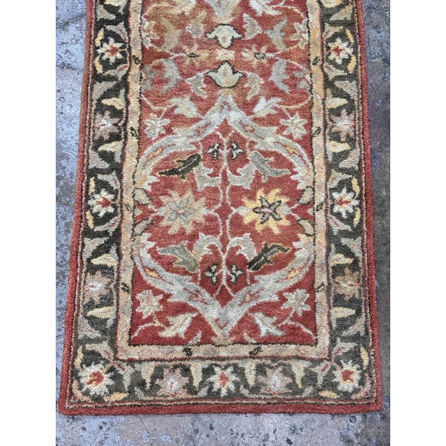 Design Plus Gallery presents a 2ft 6in x 9ft 1in Traditional Floral Wool Runner Rug. It has a terracotta-red field framed...