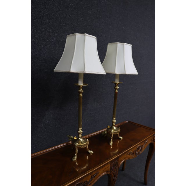 Pair of solid brass table lamps with classic trifoot bases. Each lamp features a fluted column, round bobeche detail, and...