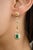 These modern dangling earrings showcase an exquisite octagon-cut emerald, elegantly framed by sparkling diamonds, all set...