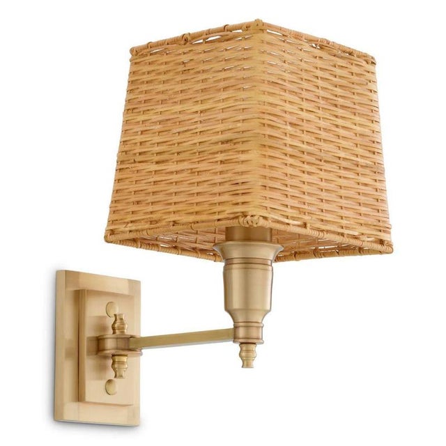 This wall lamp in antique brass finish is a refined lighting piece designed to provide soft, atmospheric illumination...