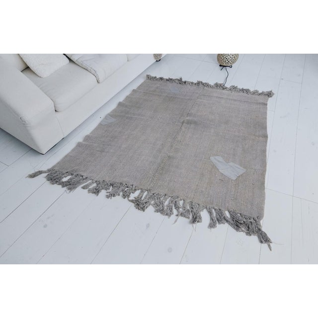 This is a vintage Turkish Oushak rug from the Mid 20th Century. The piece was hand-knotted.