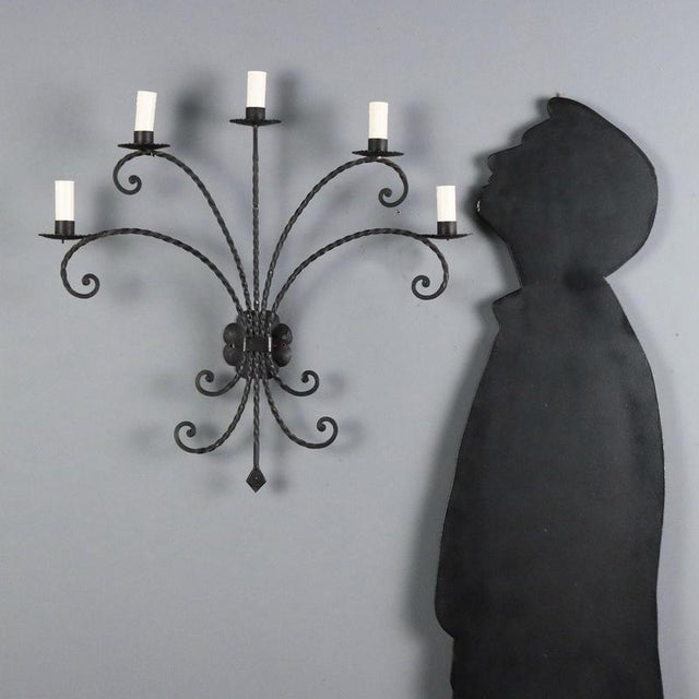 Five-light wall sconce crafted in wrought iron, featuring a twisted and scroll design that evokes elegance and...