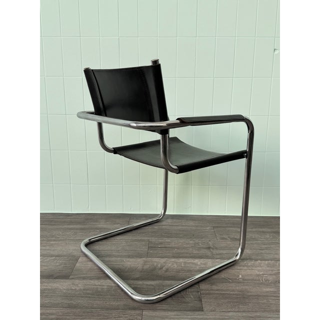Italian chair made in the 1970s Chrome-plated steel frame and black leather seat and backrest. The armrests are also...