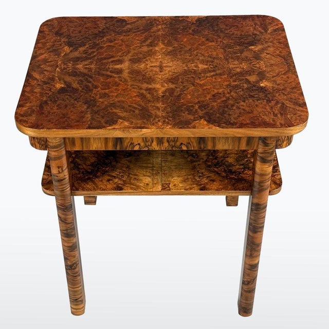 Art Deco coffee table featuring a clean, geometric design and a striking burr veneer pattern. The rectangular top with...