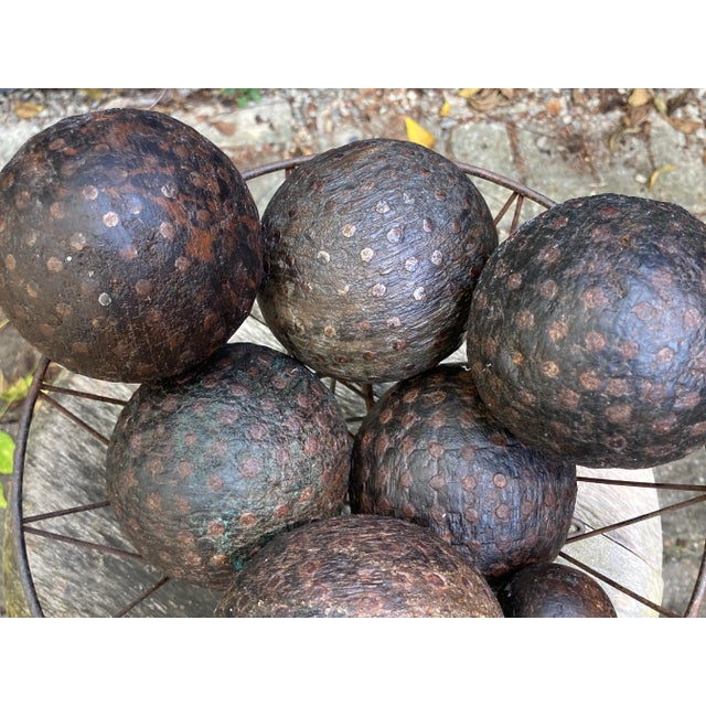 A set of 6 hand made wood and nail head lawn bowling balls,including a small wood marking ball, a wrought iron basket is...