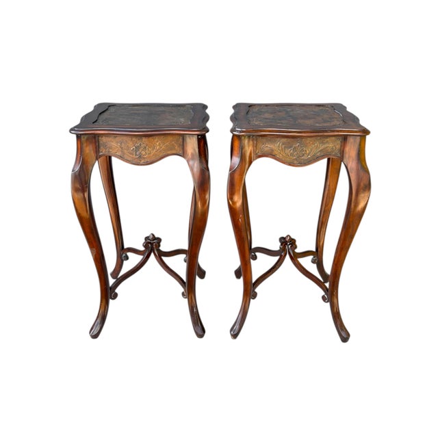 A pair of Maitland-Smith carved side tables in mahogany. Square serpentine table tops are inset with highly decorative...