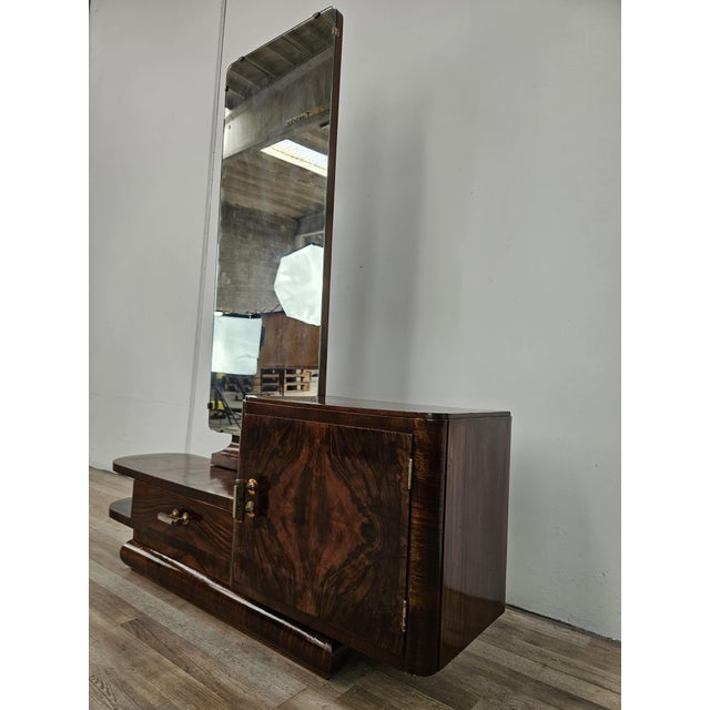 An elegant Art Deco dressing table dating back to the 1940s, featuring a refined walnut frame and a sinuous, geometric...