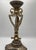 Elegant vintage Neoclassical-style brass candle holder featuring an ornate urn-form design with classical detailing and a...