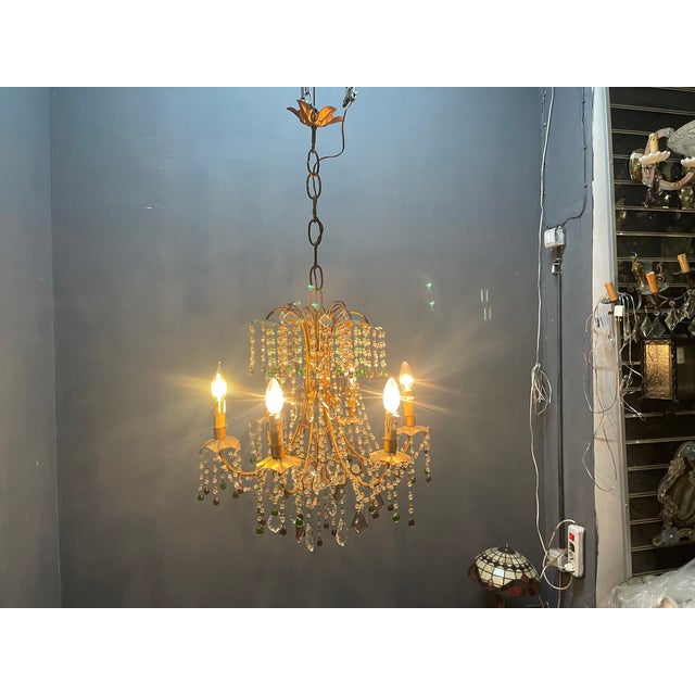 Elegant 1950s florentine tole chandelier with a beautifully gilded gold frame, adorned with cascading crystal garlands and...