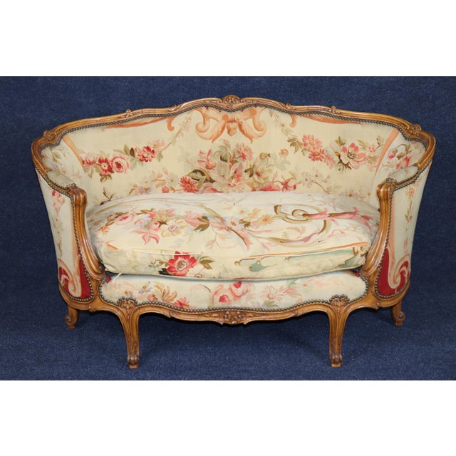 An exceptionally beautiful and very rare matched pair of French Louis XV-style settees, distinguished by their graceful...