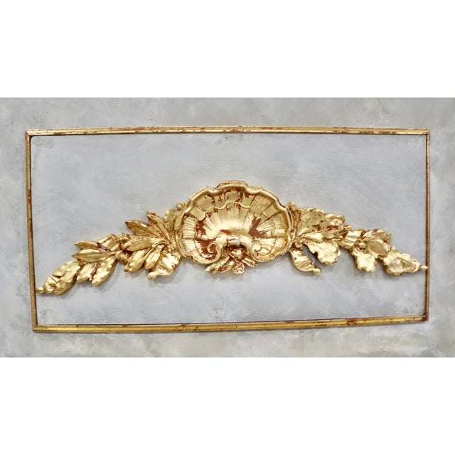 French Trumeau Mirror With Giltwood Carved Gold Leaf Shell and Leaf Swags Pediment. I do not know the manufacturer of the...
