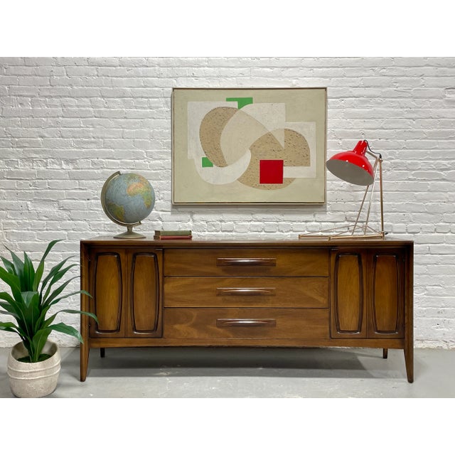 Walnut Mid Century Modern Credenza Dresser by Broyhill Premier, c. 1960's. Boasting gorgeous wood grains, this long...
