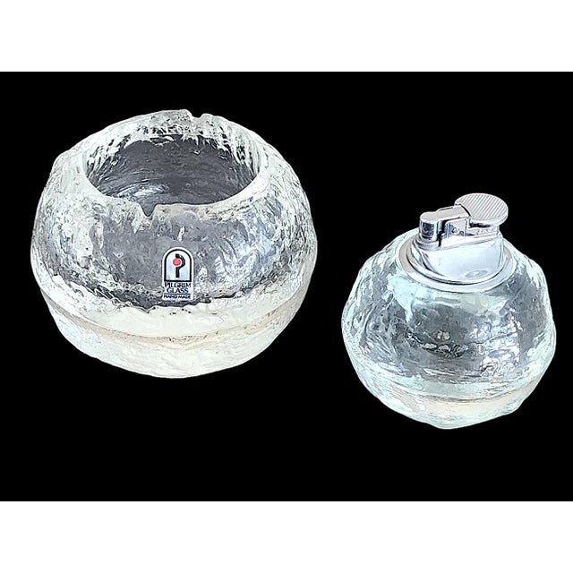 Offered is a set of textured art glass Snowball/Snowman ashtray and its companion table lighter, made by Pilgrim Glass in...