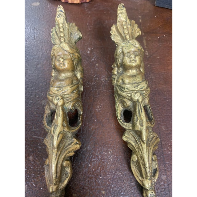 Elegant pair of antique French bronze ormolu furniture ornaments, beautifully cast with figural detail and flowing foliate...