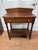 A mid-19th century American washstand in cherry, in the late Sheraton taste. A gabled splashboard with scrolled ends rises...