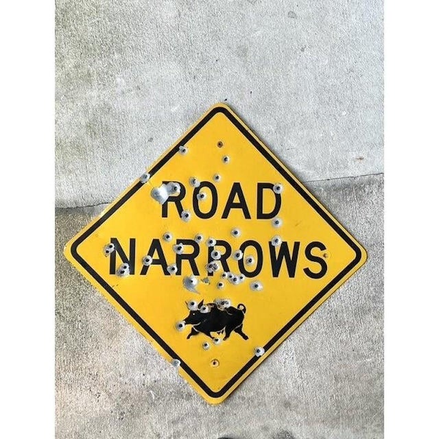 This authentic vintage "Road Narrows" sign serves as a compelling work of industrial folk art, masterfully bridging the...