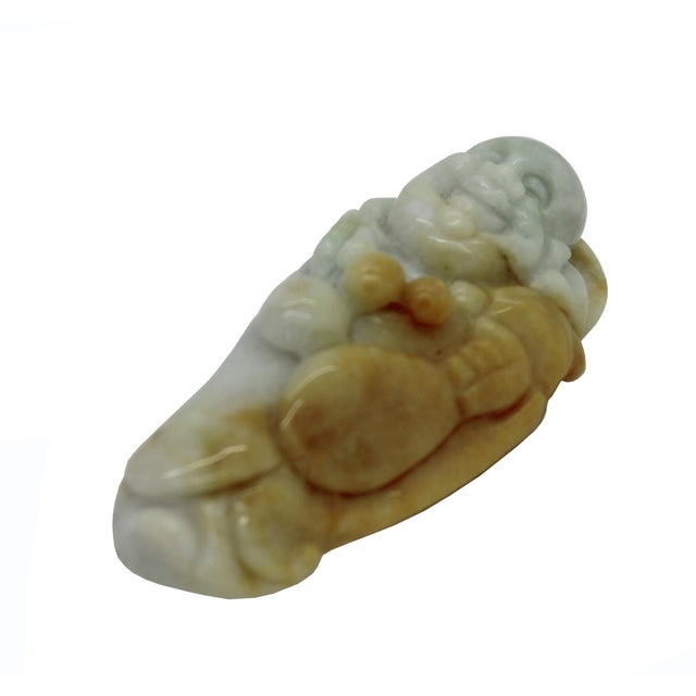 This stone figure, likely carved from natural jade stone, depicts a jovial, laughing monk—commonly identified as Budai or...