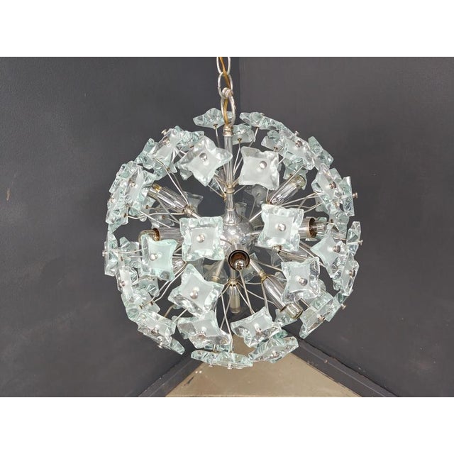 Striking sputnik shaped chandelier with blue hammered glass glasses mounted on a chrome frame. Once illuminated, this...