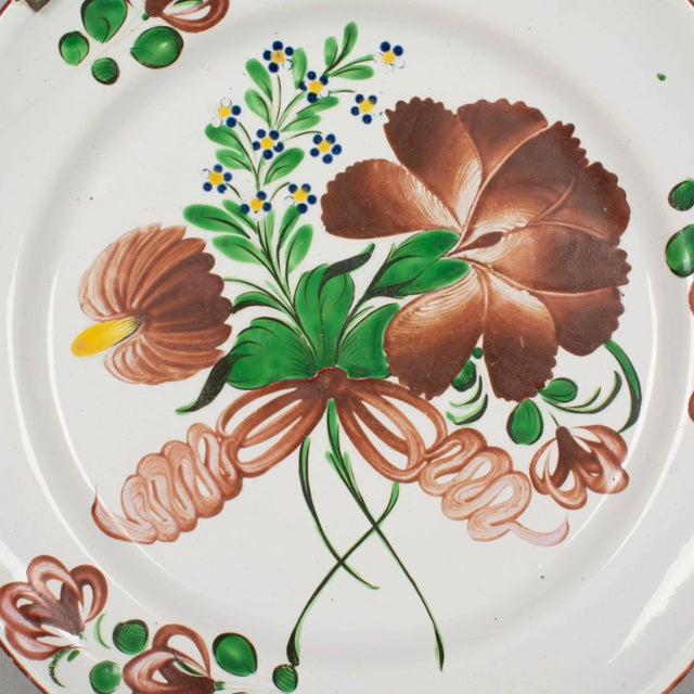 A 19th century French faience charger or platter with typical hand painted burgundy floral decoration from St Clement in...