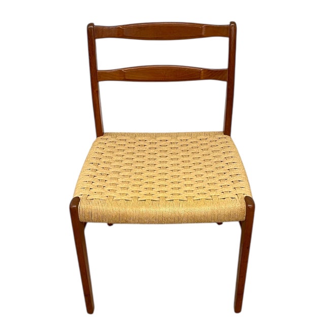 This mid-century Danish modern dining chair features a wood ladder-back frame paired with a woven paper cord seat in a...