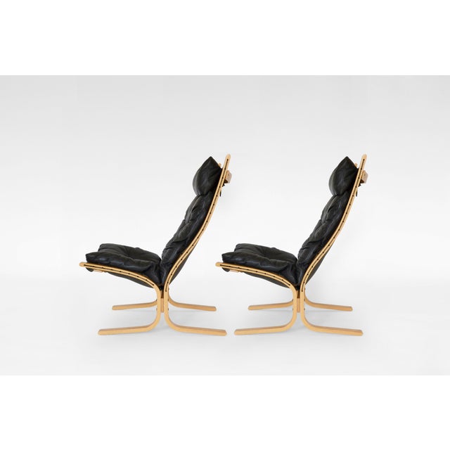 A pair of Siesta lounge chairs with high backrest, designed by Ingmar Relling and produced by Westnofa. Upholstered in a...