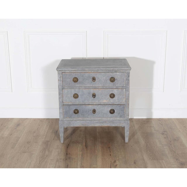 A delicate and beautifully aged Swedish chest of drawers, circa 1920, painted in a soft grey-blue tone that evokes the...
