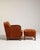 A classic Art Deco lounge chair paired with an ottoman, reflecting the period’s focus on comfort and geometric elegance....