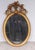 Fine Regency style giltwood oval mirror, with elegant beaded surround and a beautifully carved crest centred by trailing...