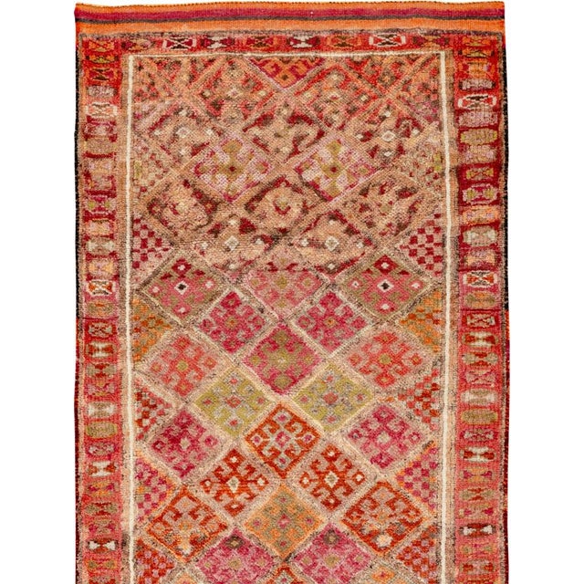 This mid-20th-century Turkish Anatolian runner presents a vibrant allover lattice of diamond-shaped compartments arranged...