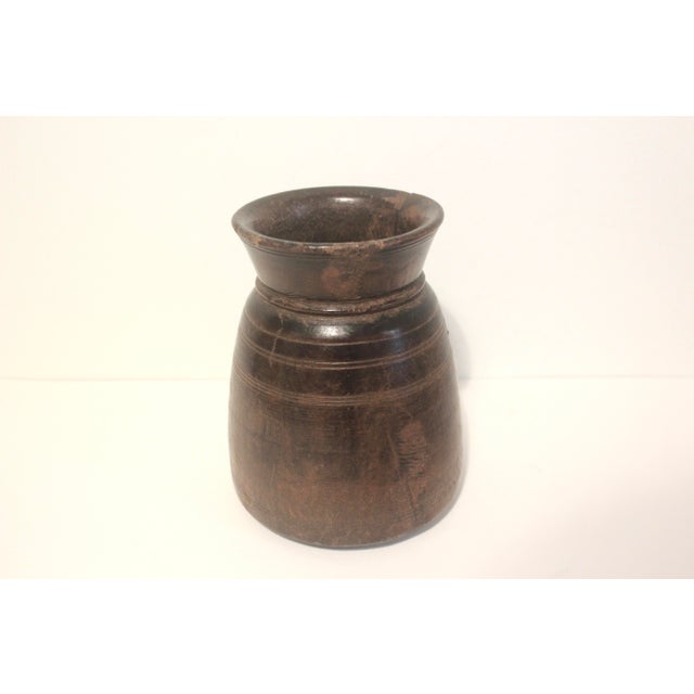 Carved wood vessel with chippy edges and a repair with a staple and filler to fix a natural crack in the wood. The base is...