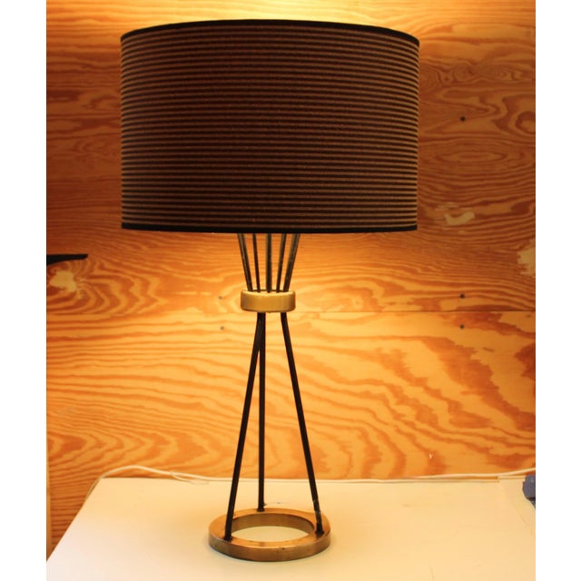 Small table lamp with 3 wrought Iron rods on a solid brass ring, tapered to a small ring that flares out to hold light...
