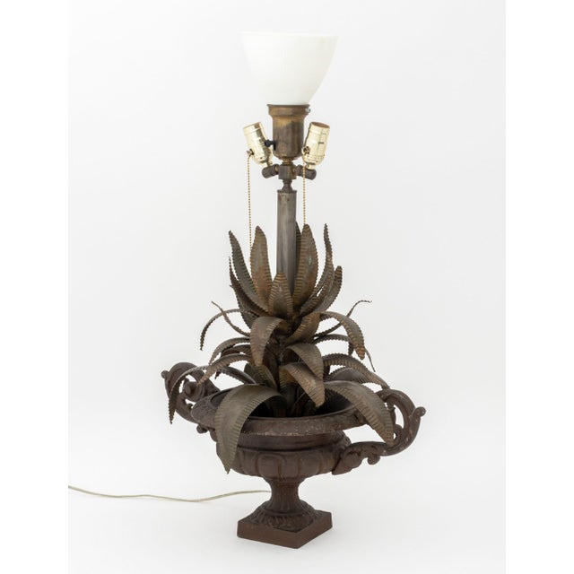 Maison Jansen Style Cast Iron and Sheet Metal Palm Leaf Motif Table Lamp, the urn with scroll form handles and milk glass...