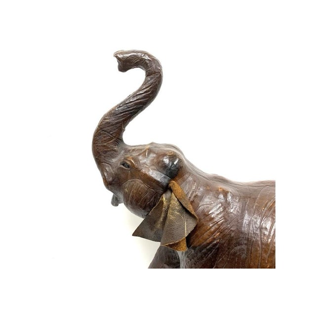 Large Mid Century Leather Elephant in striding motion with upraised trunk.The Elephant has nicely defined musculature and...
