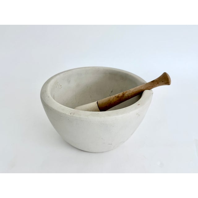 Large early 1900s porcelain mortar and pestle with a matte finish on thick walls with a pouring spout. The pestle has a...