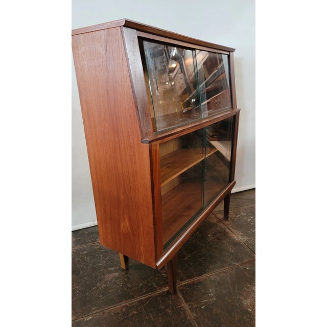 A real cute Scandinavian Danish Teak Cabinet. The glass doors slide closed stepped design look at side profile. Nice for...