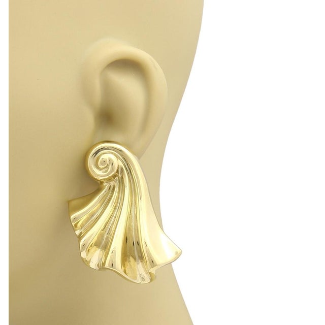 These large 18k yellow gold shell curled earrings are a vintage piece of fine jewelry. The huggies style of the earrings...