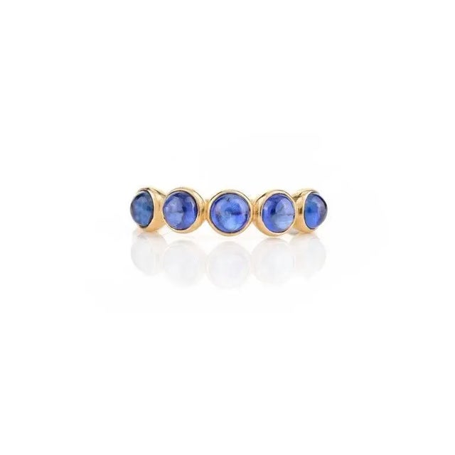 This is part of Chairish’s Fine Jewelry assortment. Blue Sapphire Bezel Set Band Stacking Ring in 14K Gold symbolizes the...
