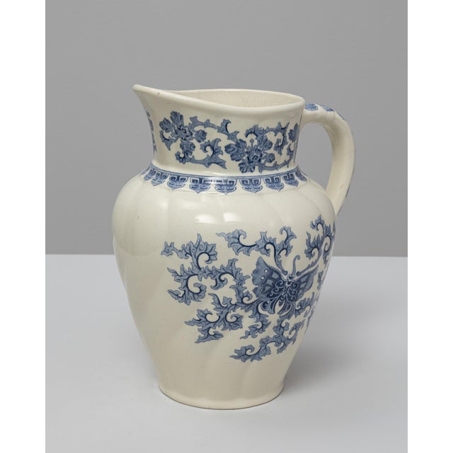 This 20th Century Belgian blue Chinoiserie ceramic pitcher showcases a graceful silhouette enriched with delicate Eastern-...