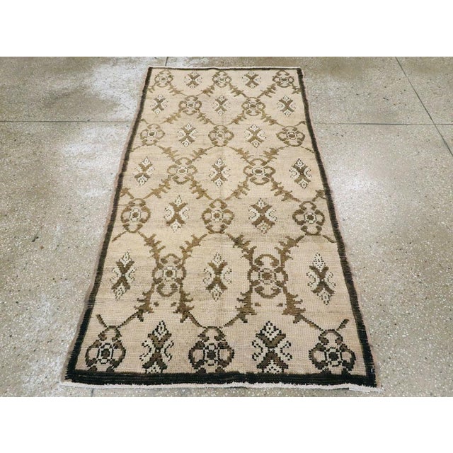 A vintage Turkish Anatolian throw rug. The abrashed sandy ivory ground of this rural Turkish scatter displays a three by...