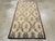 A vintage Turkish Anatolian throw rug. The abrashed sandy ivory ground of this rural Turkish scatter displays a three by...