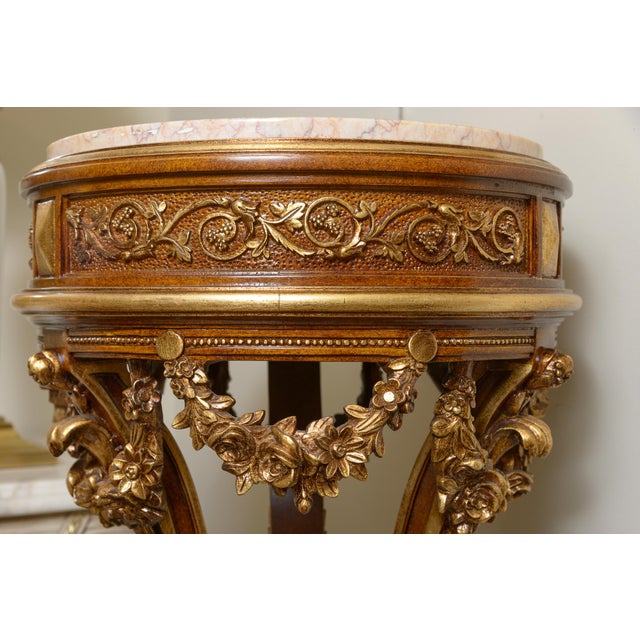 Tall and elegant marble top gilt and wood highly decorated with carved swags with three individual shaped columns ending...